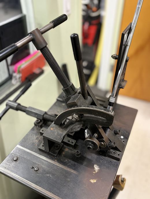 A club held in a repair jig at The Complete Golfer